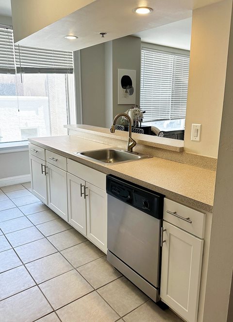 Renovated kitchen with white cabinets and stainless steel appliances